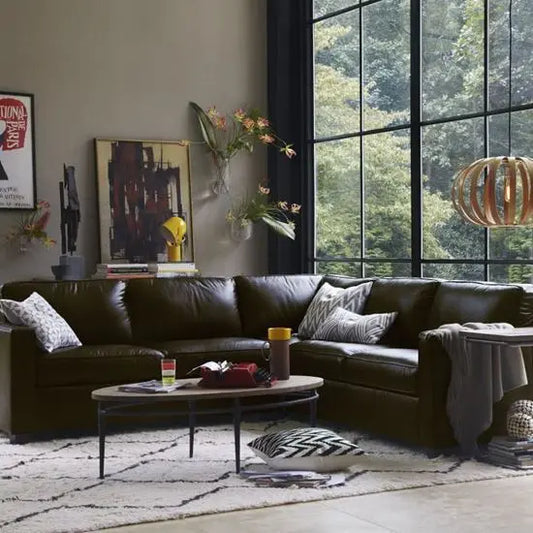An oval-shaped mango wood top coffee table with a hammered iron base.