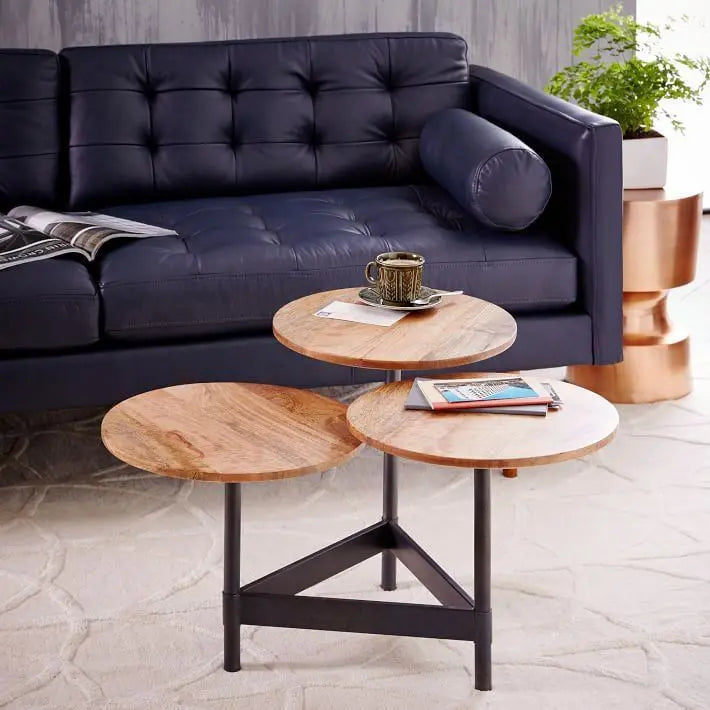 A modern black metal and mango wood coffee table with circular table tops.