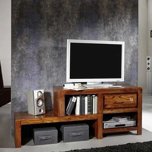 A wooden DeeZiL TV Cabinet with one drawer, featuring a Holo-Step design. The TV cabinet has books and a speaker on it, set against a dark wall.