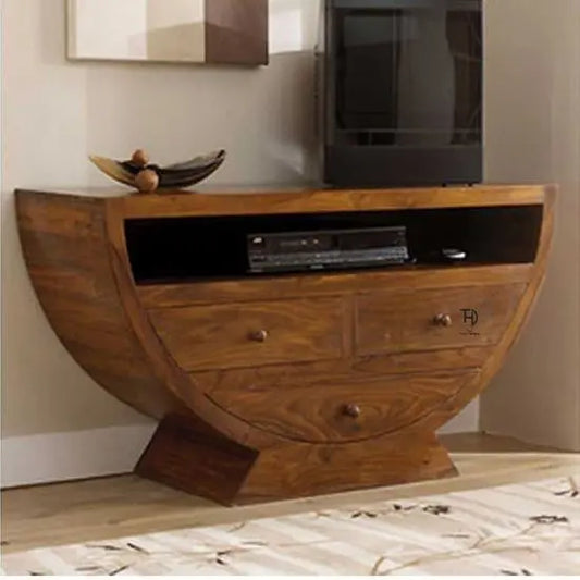 A natural wood finish TV cabinet with three drawers and an open shelf, placed against a wall with decorative items on top.