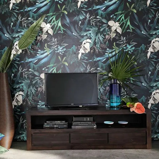 A dark brown DarKeen TV Cabinet with three drawers and one open shelf, placed against a wall with floral wallpaper. A flat-screen TV is placed on top of the cabinet, and there are decorative items on the shelves.