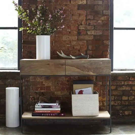 Industrial console table with a steel frame and mango wood drawers and shelves.
