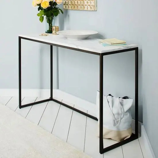 A contemporary style marble console table with a white marble top and mild steel framework.