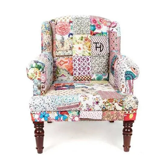 A Maharaja sofa with a multicolor patchwork design, featuring round wooden legs and an armrest, intended for indoor use.