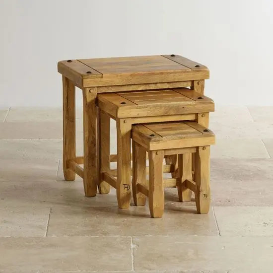 A set of three Devi stools made of mango wood, stacked together, with visible wood grain and natural finish.