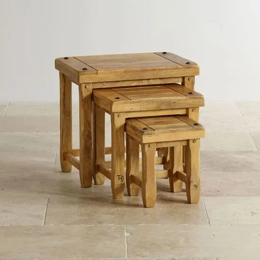 A set of three Devi stools made of mango wood, stacked together, with visible wood grain and natural finish.