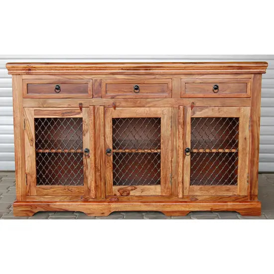 A wooden sideboard with three drawers and three doors with handmade iron jali featuring a geometric pattern.