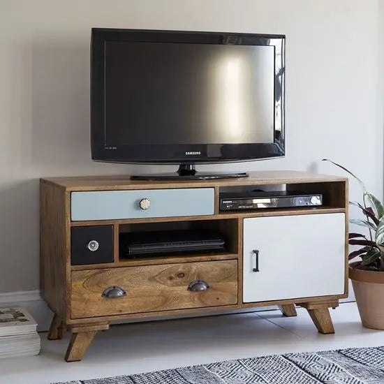 A detail shot of a multicolor TV cabinet made of solid mango wood, showing different colored wood grains and a drawer with a metal handle.