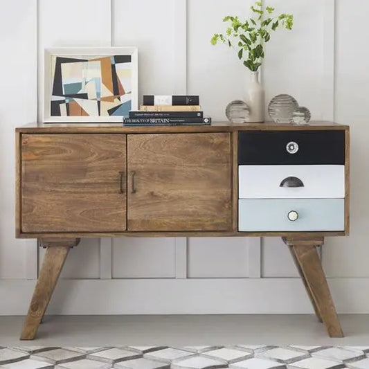 A wooden sideboard with a black and white drawer, featuring angled wooden legs. Made in mango wood.
