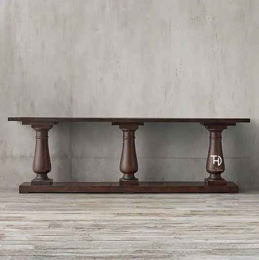 A rectangular console table made of Sheesham wood with a mahogany finish, featuring three turned legs.