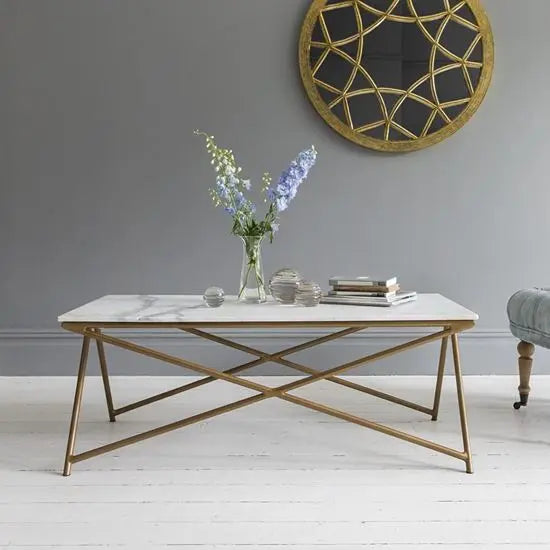 A white marble coffee table with a metallic gold base.
