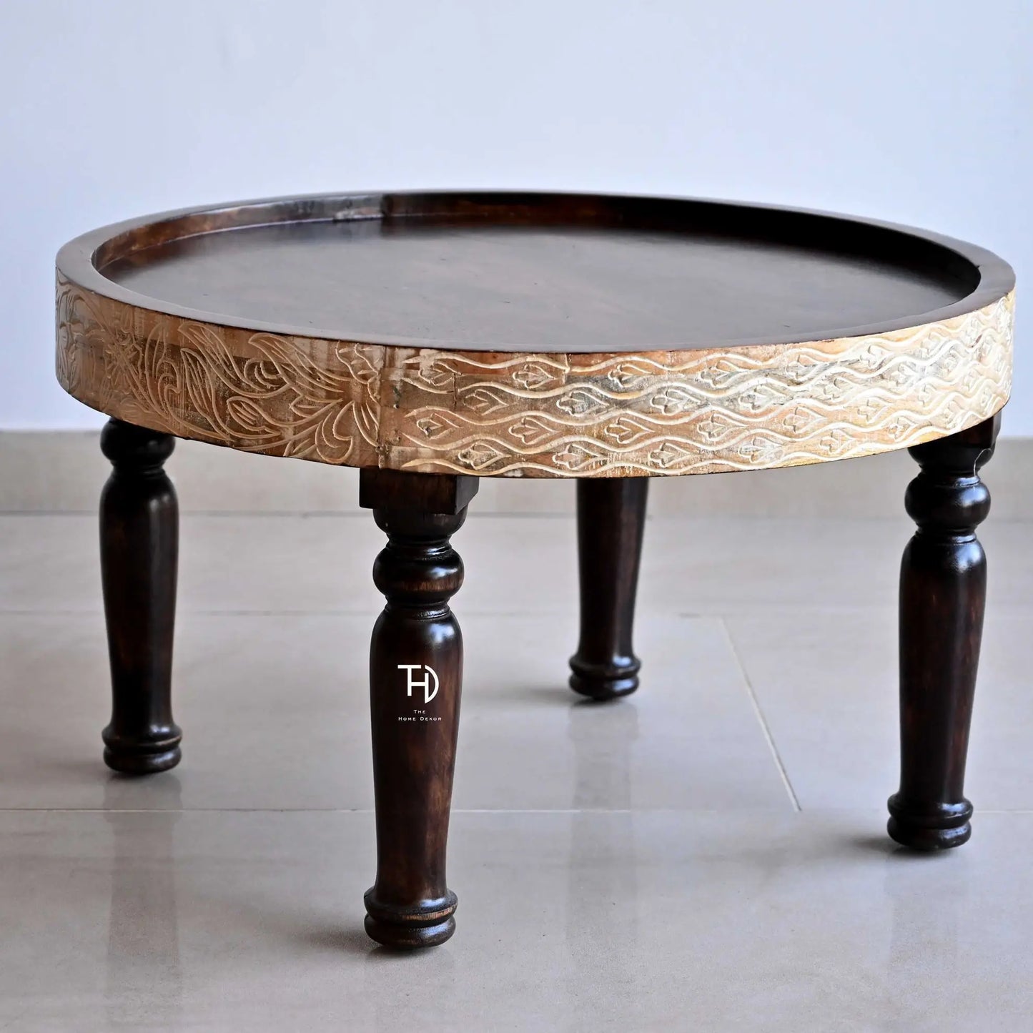 Round Mango wood trendy ringbud coffee table with intricate carvings and curved legs.