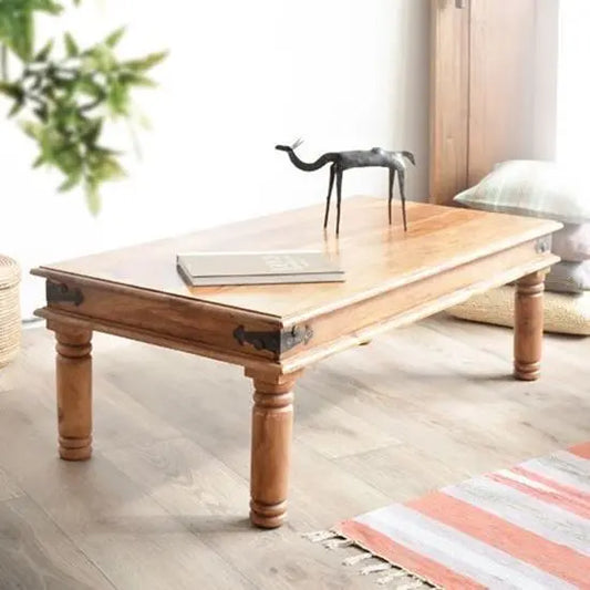 A rectangular vintage coffee table made of sheesham wood with decorative iron corners.