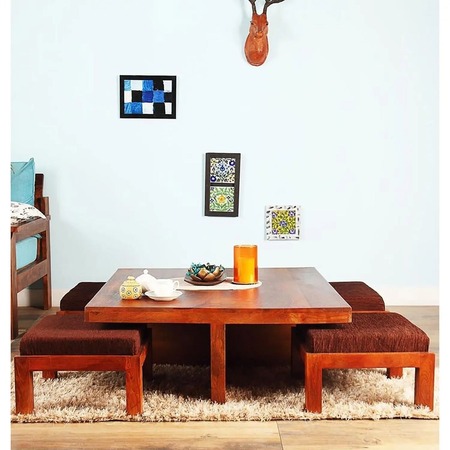 A brown wooden coffee table with four attached Stool seats arranged in a square formation.