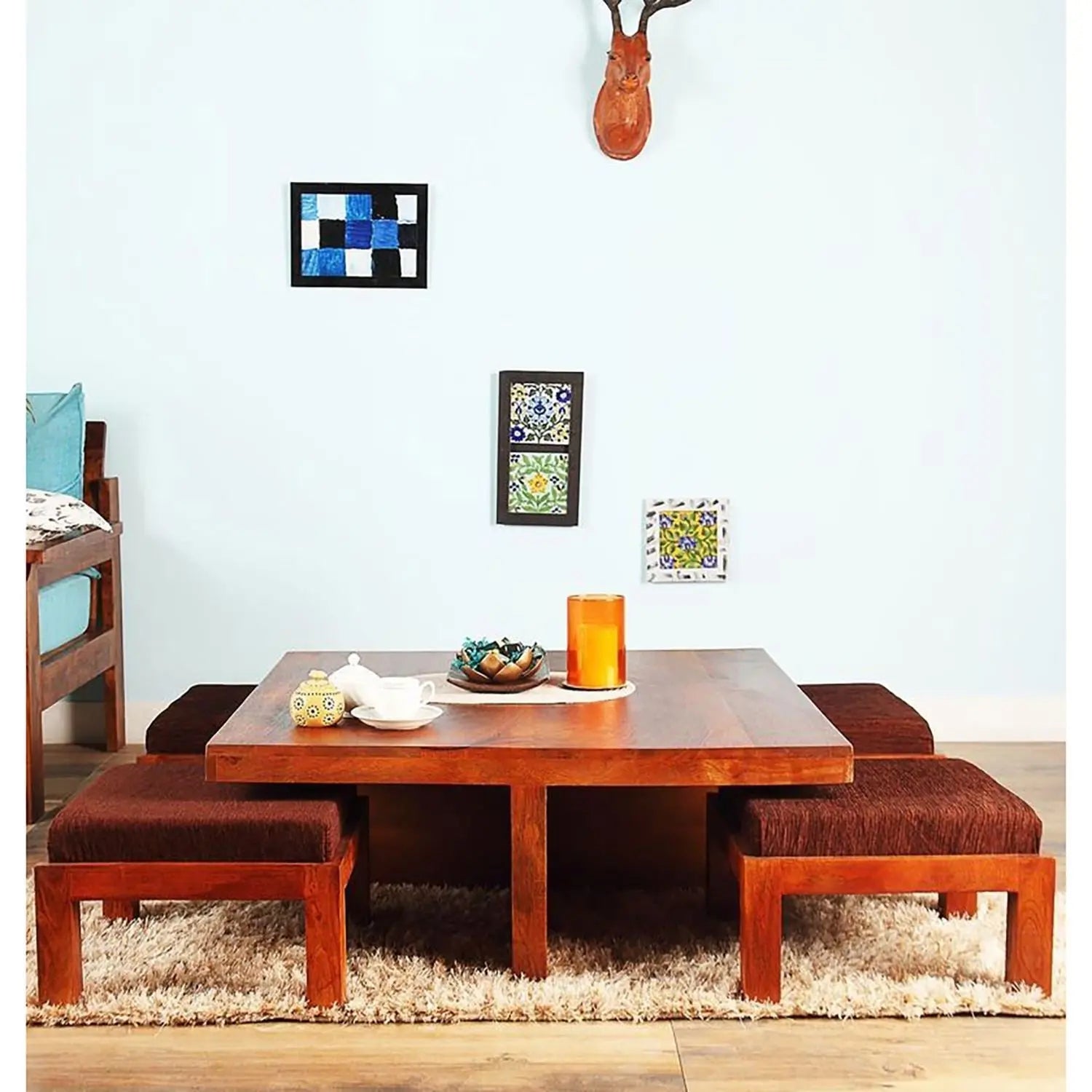 A brown wooden coffee table with four attached Stool seats arranged in a square formation.