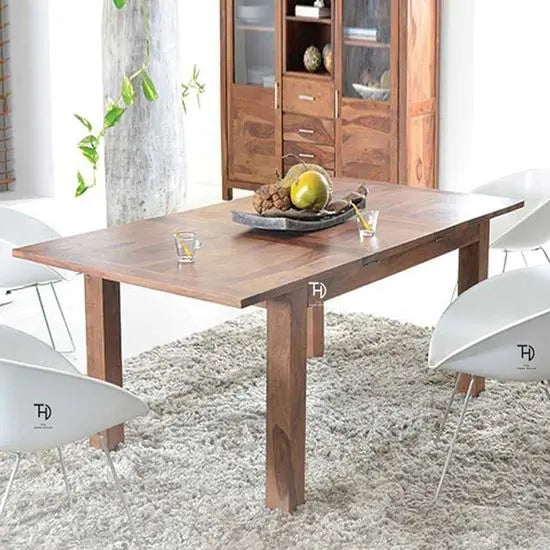 An extension dining table made of sheesham wood with a contemporary design.