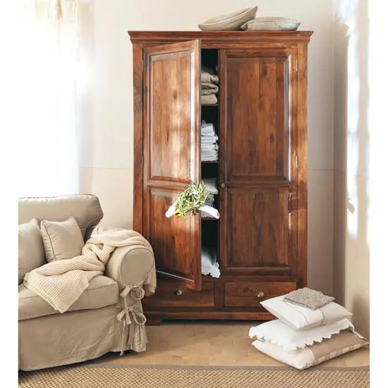 A vintage wooden wardrobe with two doors and drawers. The wardrobe is open, revealing hanging clothes and storage space.