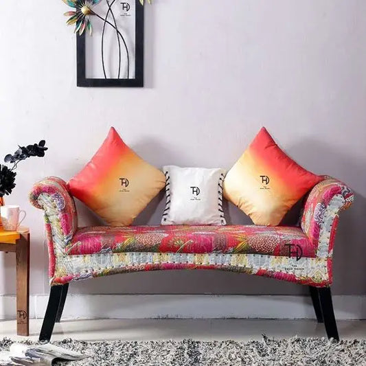 An Amira Blossom Bench with multicolor fabric upholstery and dark wood legs.