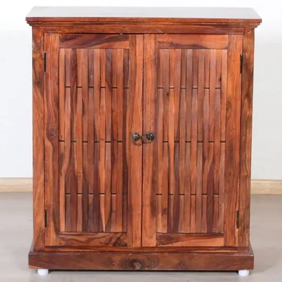 A wooden Latin shoe rack with closed doors, made from solid Sheesham wood with metal handles, intended for indoor use.