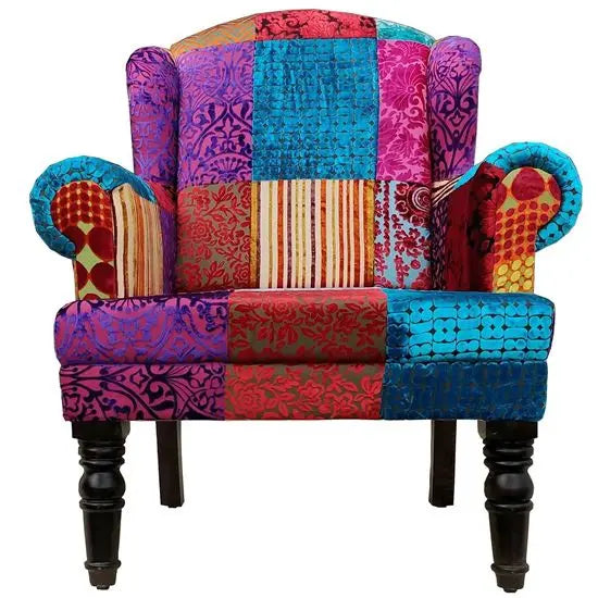 velvet upholstered Maharaja wing chair with wooden legs, featuring a solid pattern with various textures and colors.