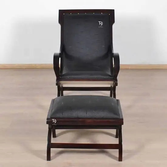 A black artificial leather upholstered Rambo Relax chair with foot stool.