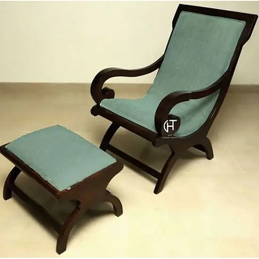 A green upholstered Rambo relax chair with a matching stool, made of Sheesham wood with walnut stain finish.