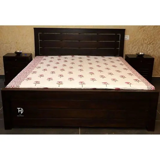 Handcrafted wooden bed with a floral pattern on the bedding, a solid brown finish on the legs, and front drawer storage.