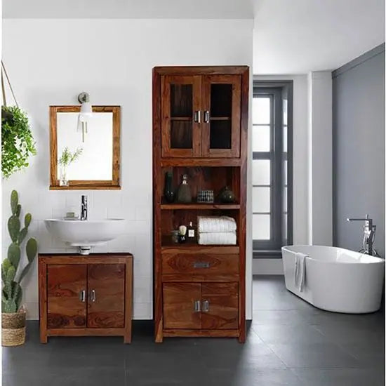 A tall Turner bathroom cabinet made of solid Sheesham wood with four doors and visible drawer units, placed in a bathroom.