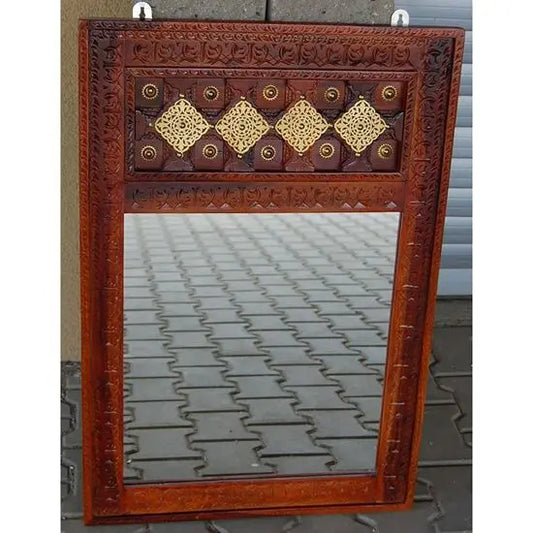 A vintage mirror frame with a brown honey-like finish and decorative elements in a geometric pattern.