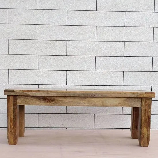 A compact, three-seater dining bench made from mango wood with a natural finish.