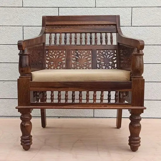 Sofa Featuring intricate carved patterns on the backrest and frame, with a beige cushion on the seat.