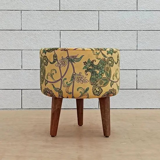 A yellow upholstered pouf with a floral pattern for kitchen.