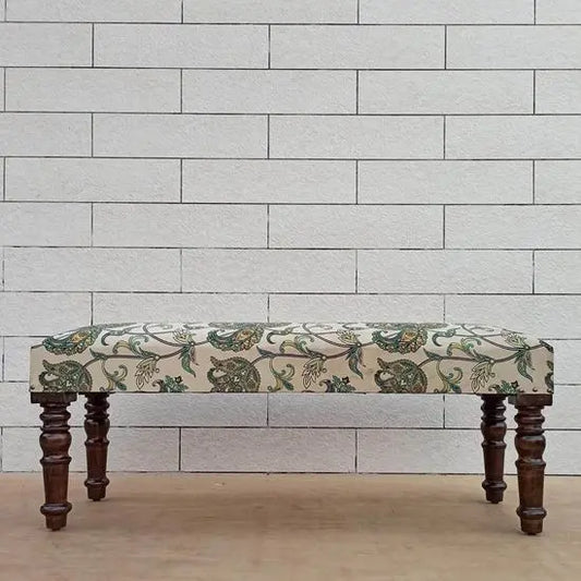 A floral upholstered bench with wooden legs.