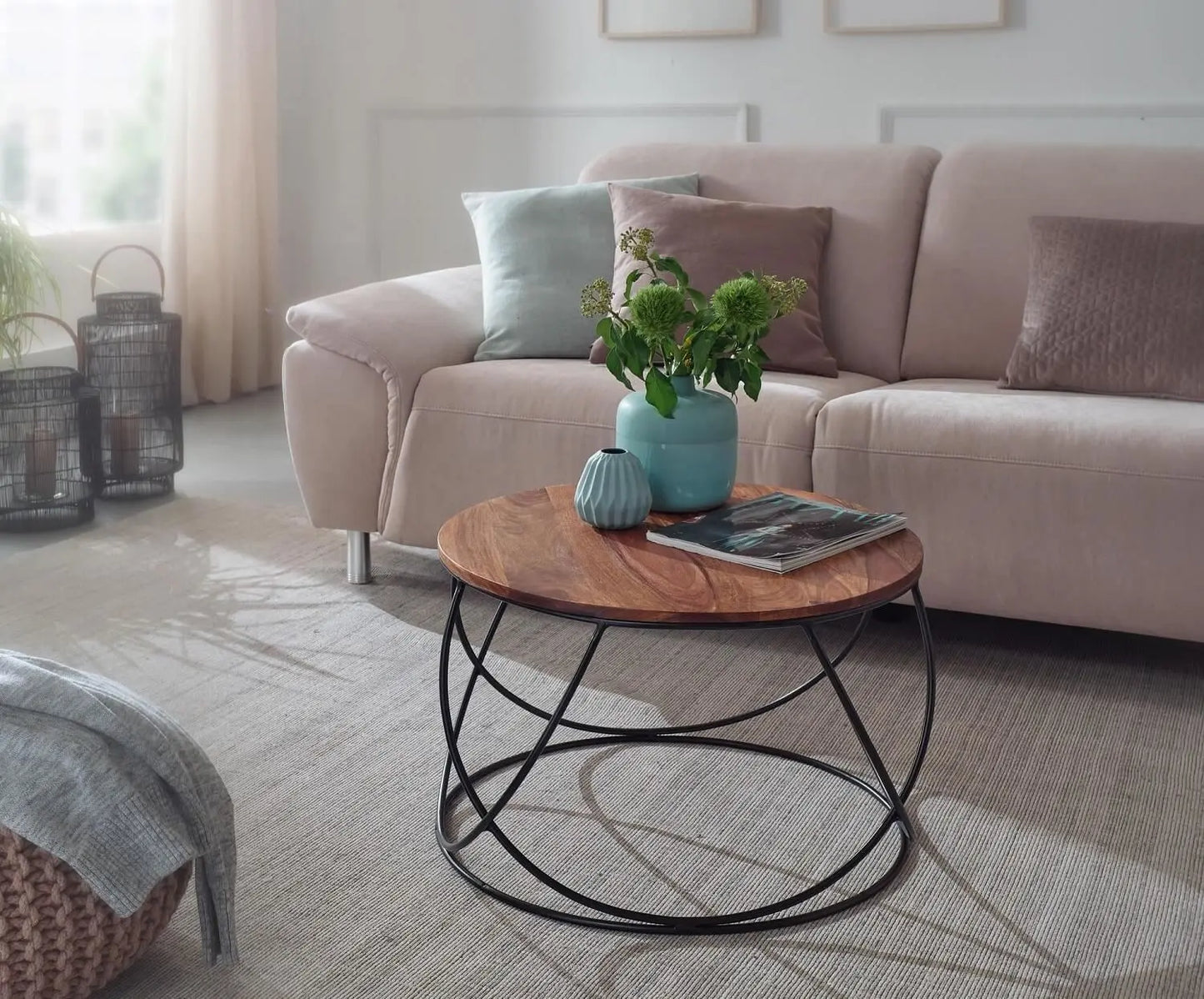 A round coffee table with a Solid sheesham wood top and black metal base.