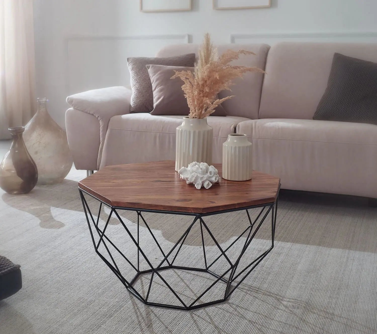A Hexagonal brown coffee table with a geometric black metal base.
