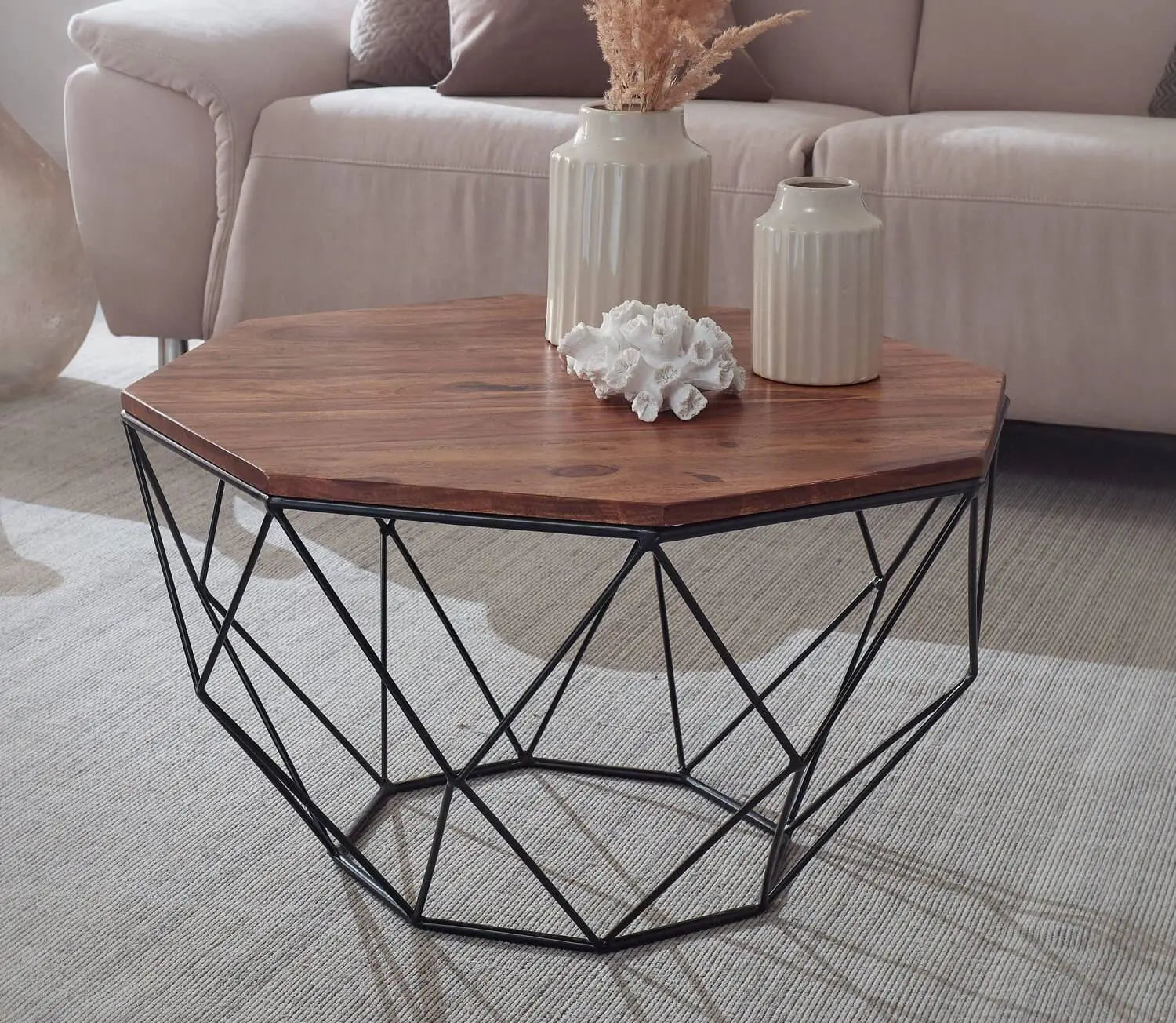 Hexagonal coffee table with wooden top and black metal frame in a living room setting.