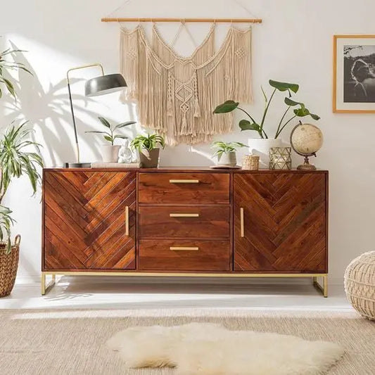 A wooden sideboard with honey and gold colors, featuring multiple storage compartments and gold-colored handles.