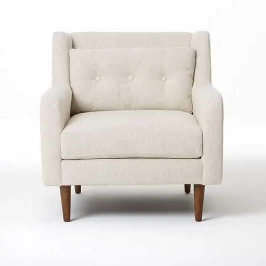 A beige upholstered single seater sofa with button tufting and knockdown turned legs.