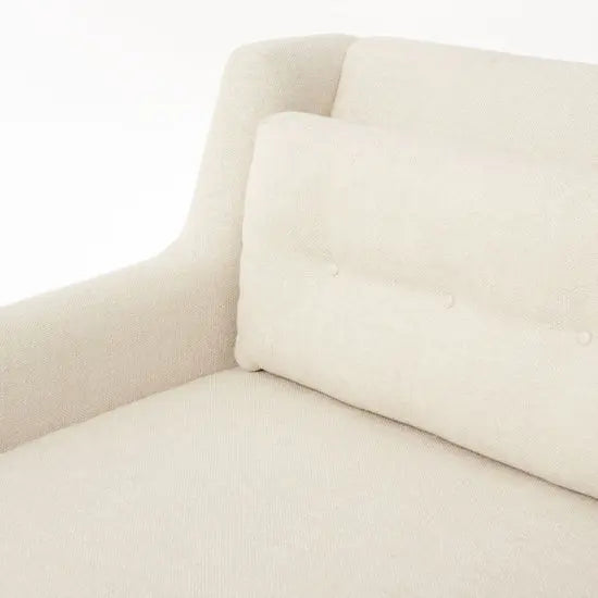 Close-up of a beige L-shaped sofa with a cushioned backrest and button details.