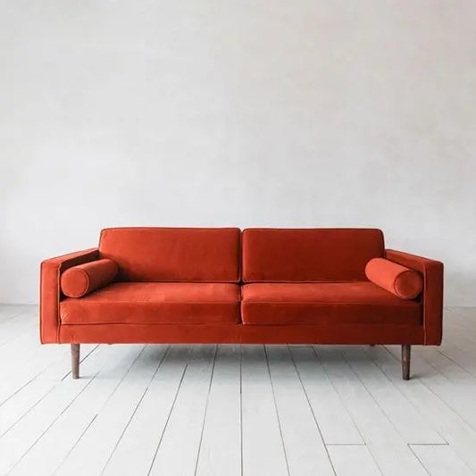 A straight line red fabric three-seater sofa with sheesham wood structure and round legs.