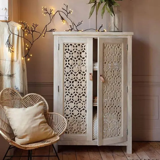 A white Fyresdal cabinet with intricate carvings, two doors, and leather handles.