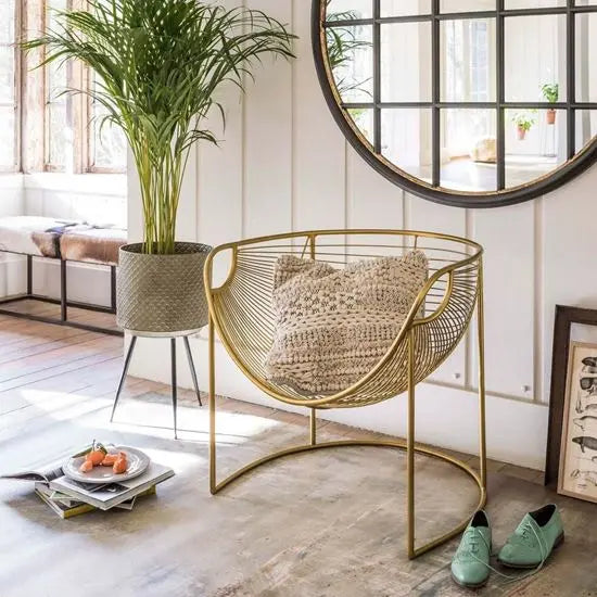 A sleek gold-colored metal designer chair.