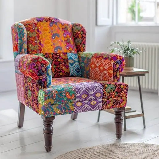 A colorful Desi Banjara fabric upholstered sofa with hand-embroidered patchwork fabric.