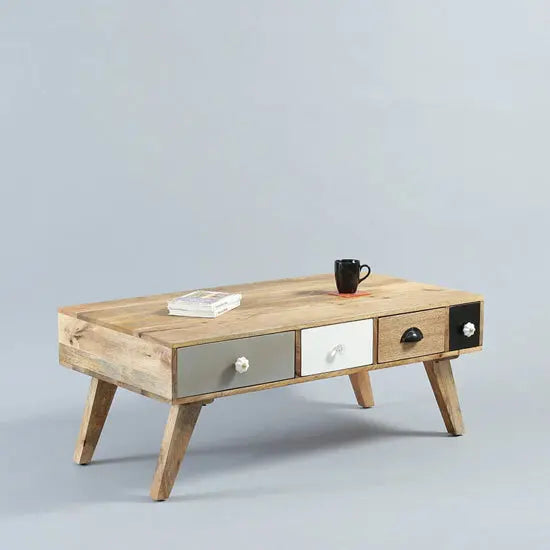 A rectangular Quatro Coffee Table with multicolored drawers and open shelves made in mango wood.