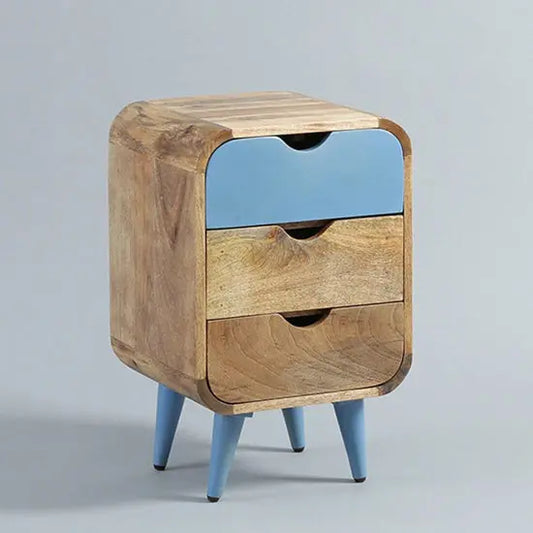 A blue bedside table made of mango wood with three drawers and pointed turned legs, the top drawer is blue and the two bottom drawers are natural wood color.