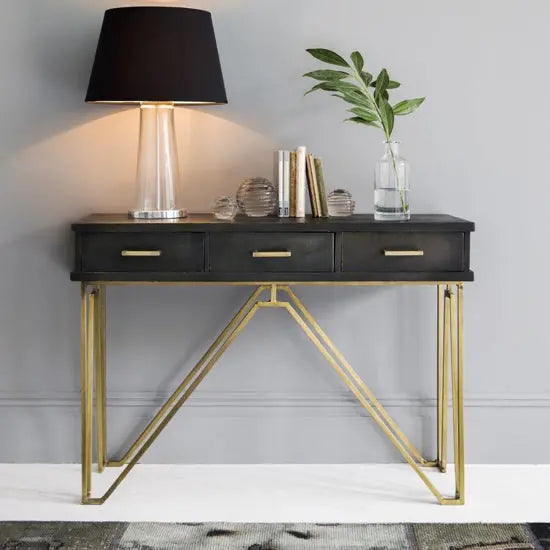 Modern console table with three drawers featuring a black top and golden iron frame.