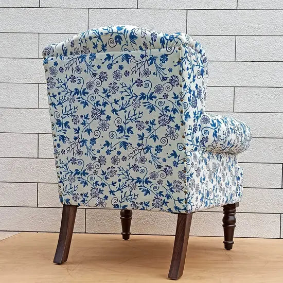 A blue wing chair with floral patterns, made from Sheesham wood with velvet upholstery.