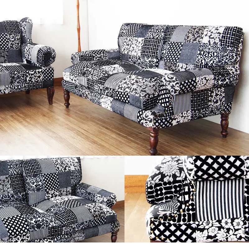 Black and white patchwork sofa with wooden legs in a living room setting.