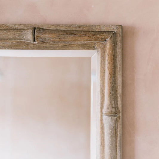 A rustic rectangular mirror with a thick, weathered bamboo-style wooden frame in a natural brown finish.