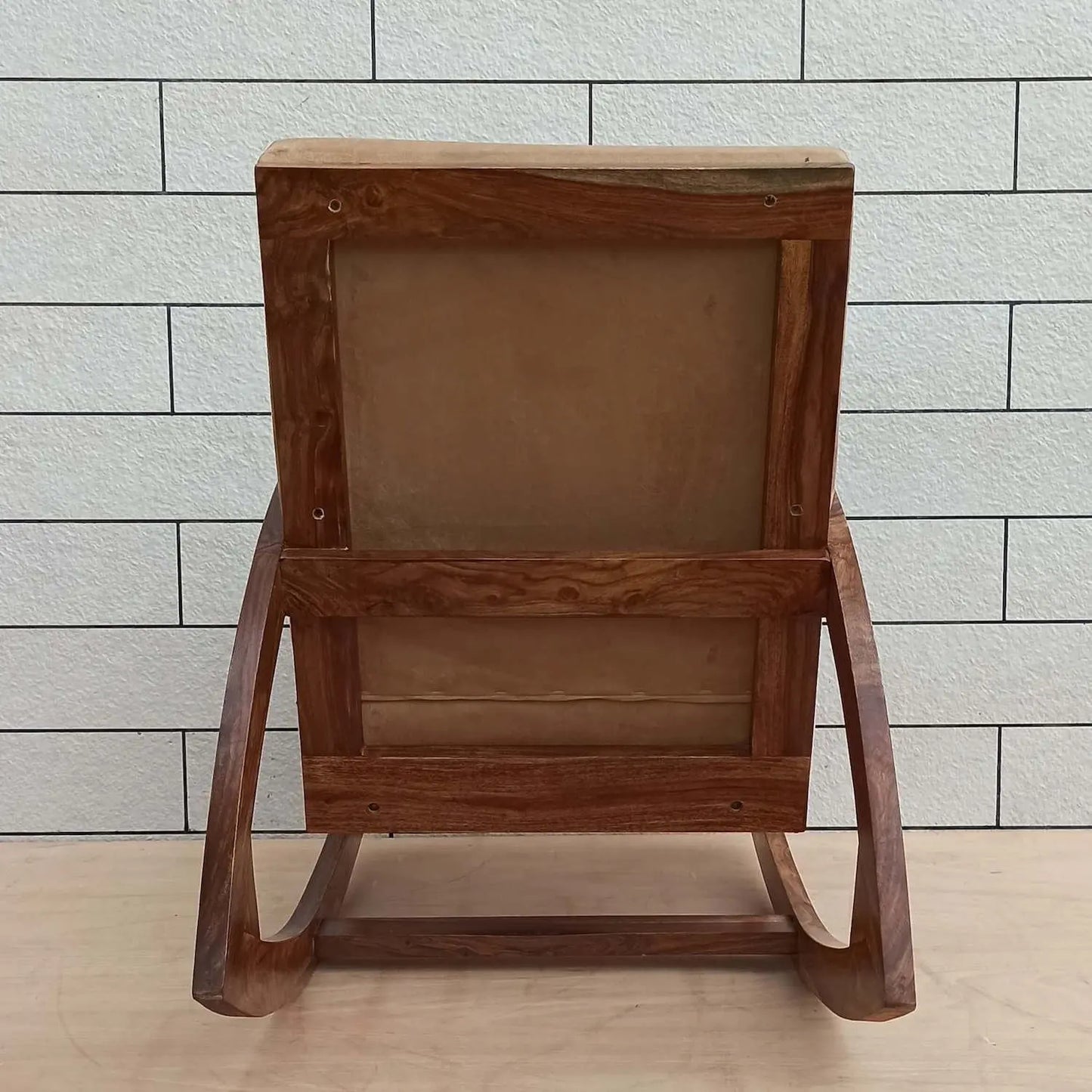 Solid sheesham wood designer rocking chair with beige cushion.
